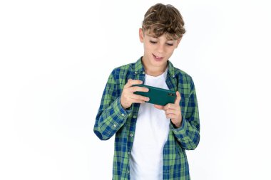 Beyaz arka planda ekose gömlekli yakışıklı bir çocuk hücresinde oturmuş video oyunları oynuyor ya da sohbet ediyor.