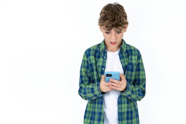 Sosyal medya haberlerini ya da önemli e-postaları okuyarak beyaz arka plan üzerine ekose gömlek giyen yakışıklı çocuk şaşırdı.