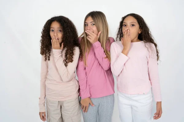 Trzy Młode Piękne Wielorasowe Dziewczynki Zakrywają Usta Patrzą Podziwem Kamerę — Zdjęcie stockowe