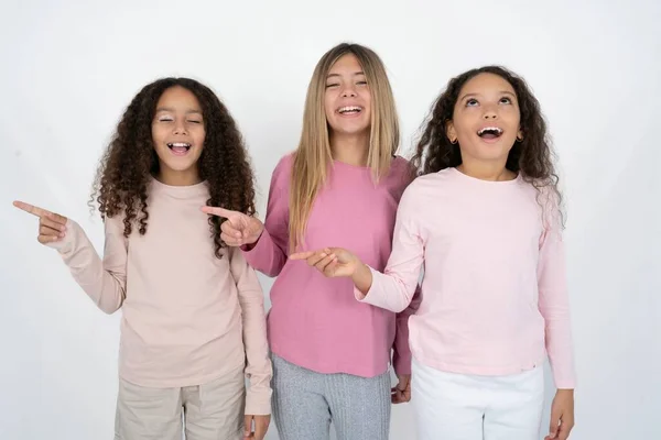 3个年轻漂亮的多种族小女孩笑得开心极了 空旷的空间展示了购物折扣的提供 好消息或意想不到的销售让她们兴奋不已 — 图库照片