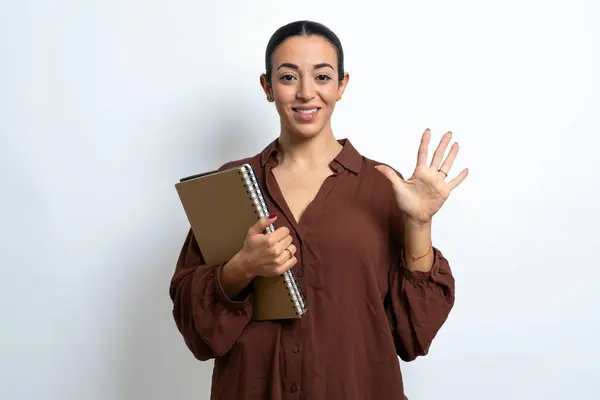 美丽的女阿拉伯学生拿着印有纸片的笔记本 用五号手指指尖 面带微笑 自信而快乐 — 图库照片
