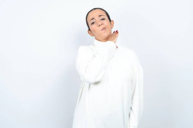 Beyaz arka planda poz veren güzel bir Arap kadın bıçakla boğazını kesiyor, saldırganlığı şiddetle tehdit ediyor..