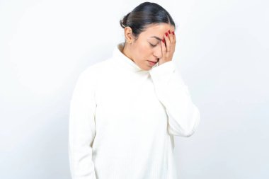 Beyaz arka planda poz veren güzel bir Arap kadın. Ağlarken suratını ellerle kapatan üzgün bir ifade. Depresyon kavramı.