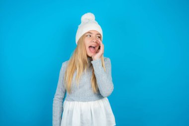 Beautiful kid girl wearing white knitted hat and blue sweater hear incredible private news impressed scream share clipart