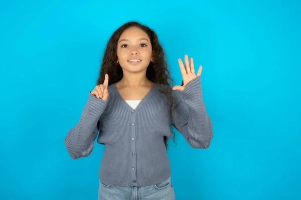 Красивая Девочка Повседневной Куртке Голубом Фоне Показывая Показывая Пальцами Номер — стоковое фото