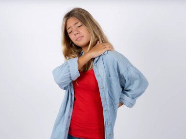 Beyaz atölyenin arka planında kot ceket giyen sarışın genç kızın sırtı ağrıyordu.