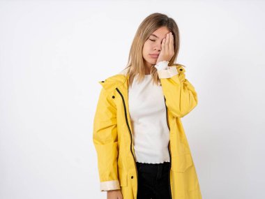 Çok çalışmaktan yorgun düşmüş sarı yağmurluk giyen güzel bir genç kız uykulu bir ifadeye, kasvetli bir bakışa sahip, yüzü elle kaplanmış, gözleri kapalı, yorgunluktan soluk soluğa kalmış, partiden partiye yorgun düşmüş.