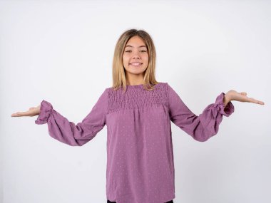 Neşeli, iyimser, pembe tişörtlü genç kız beyaz stüdyo arka planında iki avuç içi fotokopi alanı tutuyor.