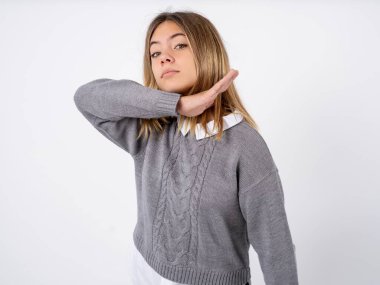 teenager girl wearing grey sweater over white studio background cutting throat with hand as knife, threaten aggression with furious violence. clipart