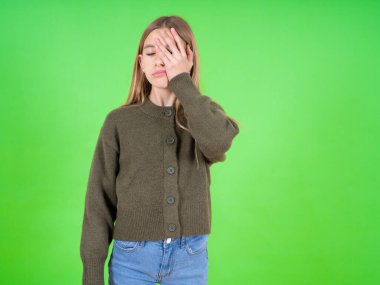 Yorgun, çalışkan, beyaz, yeşil kazak giyen güzel bir kız uykulu bir ifadeye, kasvetli bir bakışa sahip, yüzü elle kaplanmış, gözleri kapalı, yorgunluktan nefesi kesilmiş, partiden sonra bitkinlik ve bitkinliğe sahip.