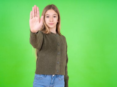 Yeşil kazak giyen güzel beyaz kız avucunun içinde şarkı söylemeyi kesiyor. Yüzünde olumsuz ve ciddi bir jest olan uyarı ifadesi. 