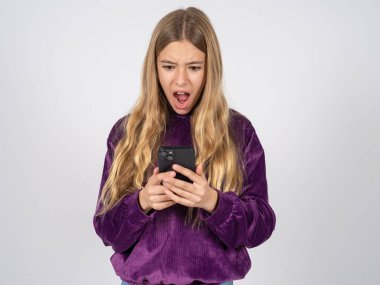 Mor kazak giyen, akıllı telefon kullanarak sosyal medya haberleri okuyan ya da önemli e-postalar atan güzel bir kız. 