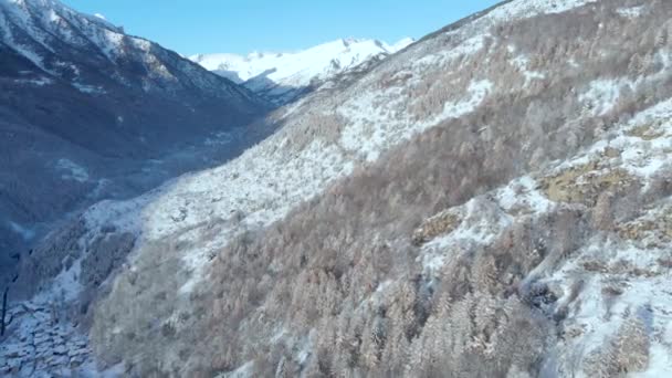 雪に覆われた山々の空中ビュークリスマスの時間で風光明媚な渓谷牧歌的な山の村と高山の森 冬の季節の白い風景 イタリアアルプス — ストック動画