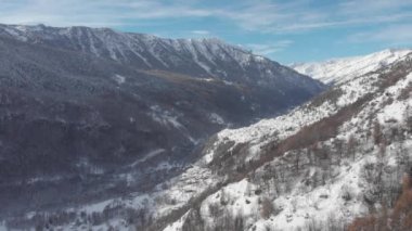 Kış mevsimi beyaz manzarası, Noel zamanı, sarmal yolu ve karlı dağlık ormanlık arazisi olan cennet manzaralı dağ köyü. İtalyan Alpleri.