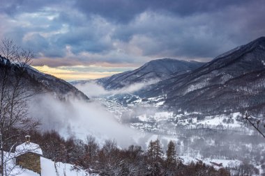 Glorious sunset in the italian Alps. Beautiful sky over snowy valley idyllic village and snowcapped mountain peaks. Winter in Piedmont, Italy. 