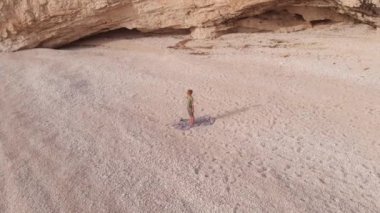 Yunanistan 'da güzel, boş bir plajda yoga yapan bir kadının hava manzarası. İyon adası Port Katsiki, Lefkada 'daki dramatik sahil manzaralı kayalık uçurumlar.
