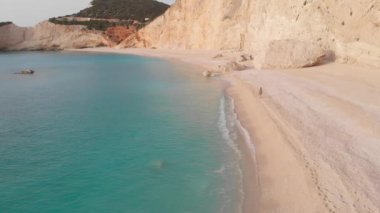Yavaş çekim: Yunanistan 'da güzel boş bir plajda yürüyen ve dinlenen kadın görüntüsü. İyon adası Port Katsiki, Lefkada 'daki dramatik sahil manzaralı kayalık uçurumlar.