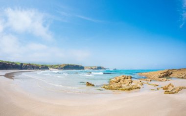 Katedrais sahili Galiçya 'da sular çekildiğinde İspanya kumtaşı gelgit havuzlarını gökyüzü kayalıklarını yansıtan geniş kayalıklar parlak ışık altında barışçıl doğal merak altında uzanır.