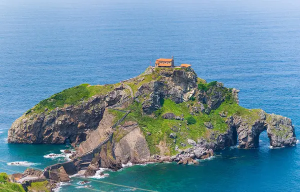 Gaztelugatxe Bask Bölgesi İspanya taştan yolu kayalık adaya doğru zigzag çiziyor derin mavi deniz ikonik kıyı inancı dayanıklılığıyla çevrili tepe inzivasına doğru