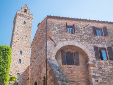 San Gimignano İtalya 'nın ortaçağ kuleleri mavi gökyüzüne karşı tarihi mimari terasotta çatılarının üzerinde yükselen canlı sokak manzaraları dikey kültür dikey gücünü yakalıyor.