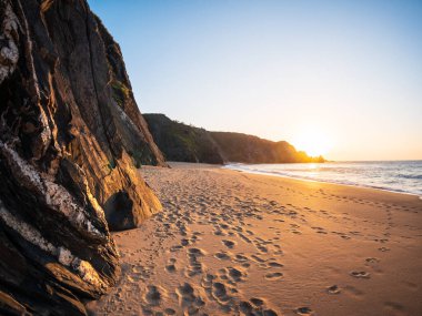 Galiçya İspanya 'nın Picon Atlantik kıyısında gün batımı. Dalgalar kumlu sahilin altın ışığı dramatik uçurumları yansıtıyor barışçıl atmosfer özgürlüğü yalnızlıktan kaçıyor