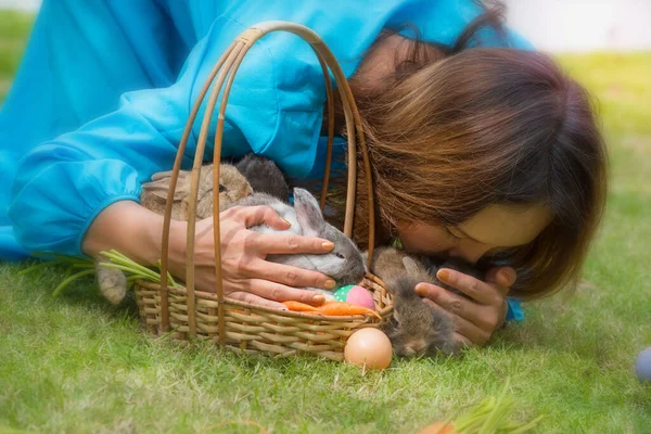 Woman kiss on Rabbit with love on green grass in Easter day. Home decorative rabbit outdoors. Little bunny, Year of the Rabbit Zodiac, Easter bunny.