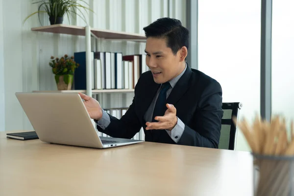 Online learning, Meeting, working and E learning concept. Casual Asian business man studying online course, meeting  via laptop computer in the office.