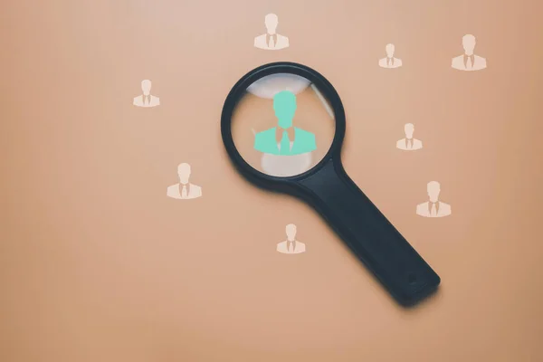 HRM or Human Resource Management, Magnifier glass focus to manager icon which is among staff icons for human development recruitment leadership and customer target group concept.