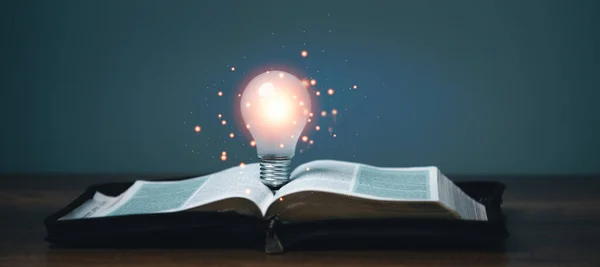 Idea of inspiration and wisdom from reading, innovation idea, Self learning or education knowledge and business studying concept, Light bulb glowing on the book,