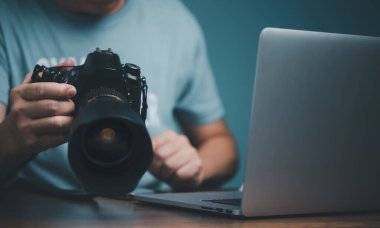 Genç adam çevrimiçi video kursundan DSLR kamera kullanmayı öğreniyor ve ayarlıyor