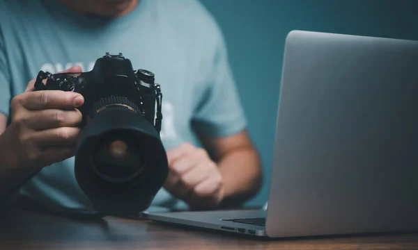 Genç adam çevrimiçi video kursundan DSLR kamera kullanmayı öğreniyor ve ayarlıyor