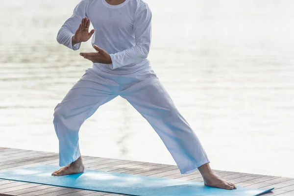 Genç adam parkta geleneksel Tai Chi Chuan, Tai Ji ve Qi gong pratiği yapıyor. .