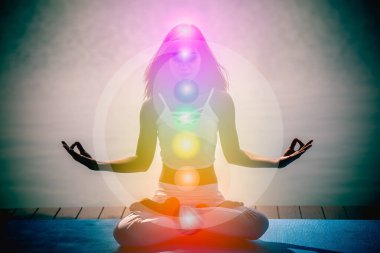 Young aura woman in yoga meditation with nature seven chakras and Yin Yang symbols.