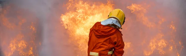 消防士火災を停止するための救助訓練 消防士は 化学水泡スプレーでホースを使用して燃焼を保護するためのハード帽子と安全統一スーツを着用 — ストック写真