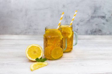 Geleneksel buzlu çay, limon, nane ve uzun bardaklarda buz. Beyaz ahşap arka plan. Yazın ferahlatıcı bir içecek.. 