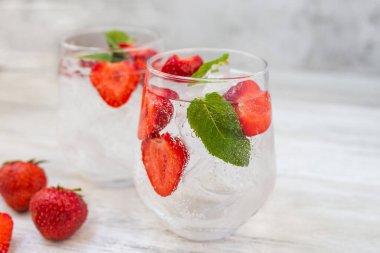 Çilekli, naneli ve limonlu su. Buz gibi yaz kokteyli ya da bardakta limonata. Detoks ve diyet. Yazın ferahlatıcı bir içecek.. 