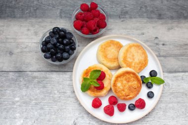 Süzme peynirli krep ya da taze ahududu ve böğürtlenli şerbetli beyaz ahşap masa. Tatlı kahvaltı ya da öğle yemeği, lezzetli tatlı. 