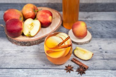 Sıcak elma şarabı, tarçınlı meyve suyu ve ahşap arka planda anason. Hafta sonları ve tatillerde lezzetli içecekler.. 