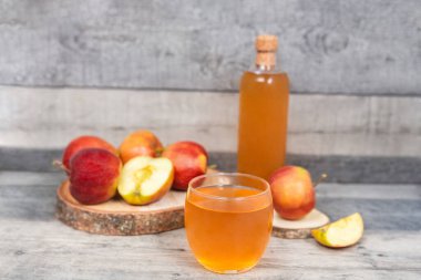 Ahşap masada bir bardak elma suyu ve elma dilimi. Vitaminli sağlıklı içecek.. 