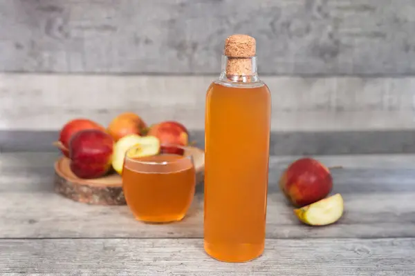 stock image Glass of apple juice and apple slice on wooden table. Healthy drink with vitamins. 