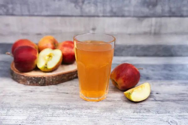 stock image Glass of apple juice and apple slice on wooden table. Healthy drink with vitamins. 