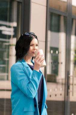 Genç zarif Asyalı profesyonel iş kadını, bayan yönetici takım elbiseli yönetici iş arasında dışarıda kahve fincanı tutuyor.. 
