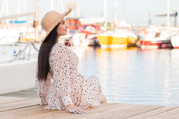 stock image Young tourist women happy enjoing to the side walking in yacht harbour. A woman enjoys a holiday by the sea. Beautiful women with hut. 