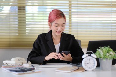 Genç Asyalı iş kadını akıllı telefon kullanıyor.  