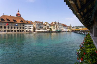 LUCERNE, SWitzERLAND, 21 Haziran 2022 - Reuss nehri üzerindeki Kapellbrucke Köprüsü ve İsviçre 'nin başkenti Lucerne' deki binaların manzarası