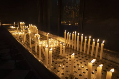 A large amount of candles lit inside a church