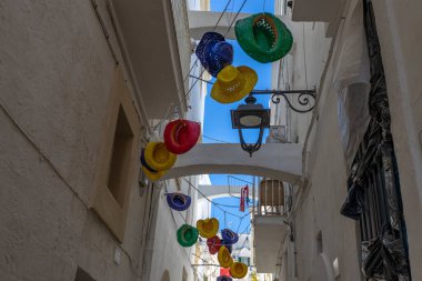 Monopoli, Puglia, İtalya 'nın tarihi merkezinde asılı renkli hasır şapkalar