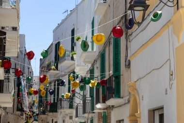 Monopoli, Puglia, İtalya 'nın tarihi merkezinde asılı renkli hasır şapkalar