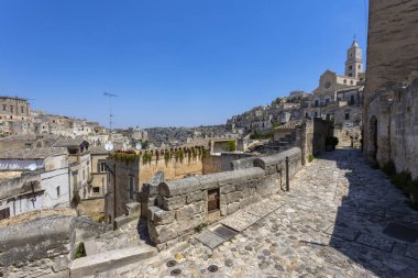 MATERA, ITALY, 18 Temmuz 2022 - Matera 'nın ünlü taşları boyunca uzanan patika, Matera, İtalya' da arka planda Katedral olan 