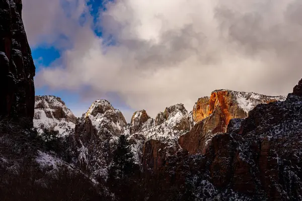 Kar, mavi gökyüzü ile kırmızı kaya dağlarını kapladı